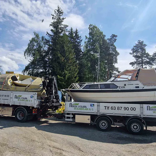 Hvit fritidsbåt blir fraktet på henger